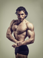 Fototapeta premium Handsome bodybuilder doing classic bodybuilding pose in studio