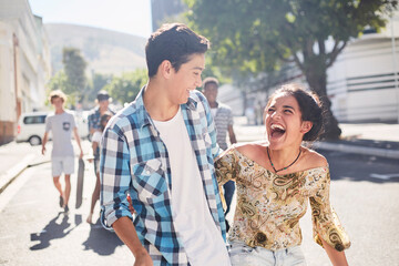 Laughing teenage couple on sunny urban street