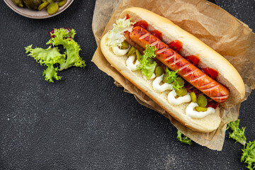 hot dog sandwich sausage, gherkin, ketchup, mayonnaise fast food smeal food snack on the table copy...