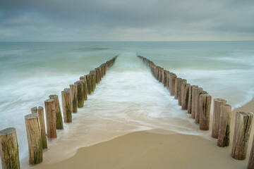 Wooden breakwater poles in the waves of the nord sea