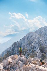 climber with a backpack and a helmet goes along a mountain path in the mountains. Girl climber in...
