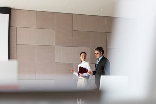 Businessman and businesswoman talking in conference room