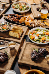 Set of tasty dishes on the table restaurant with beef steak, salad and barbecue chicken wings. Flat lay. Food menu concept