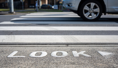 Pedestrian Crossing on the avenue in Sydney Australia, the warning word Look on street to keep...