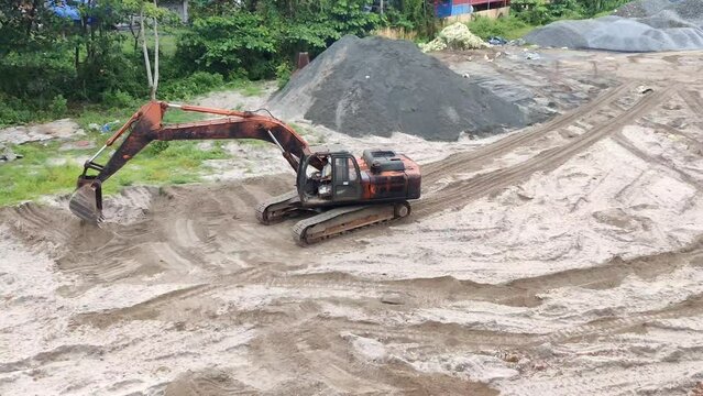 A mechanical excavator digging during earthworks on a sand mining site. Sand mining concept.