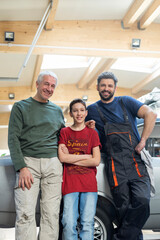 Portraits smiling multi-generation mechanic family in auto repair shop - obrazy, fototapety, plakaty