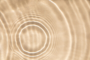 Fototapeta na wymiar Abstract nature textured background, water waves in the pool with sun reflection. Clear water with bubbles and circles on beige background