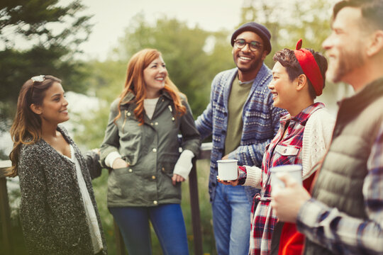 Friends talking and drinking coffee on balcony