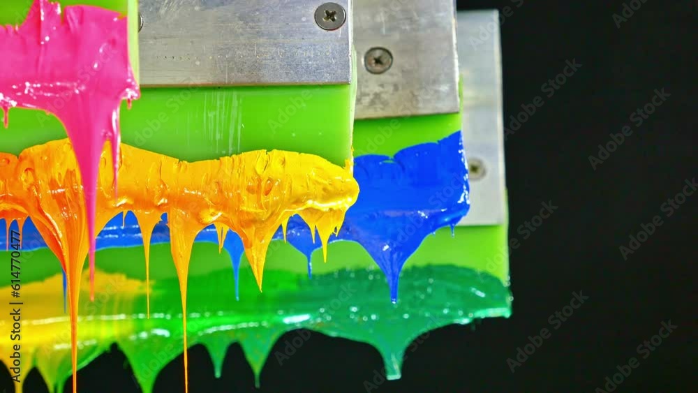 Poster colorful plastisol ink sticks are stretched on the printer handle..printing on tee shirts and fabric