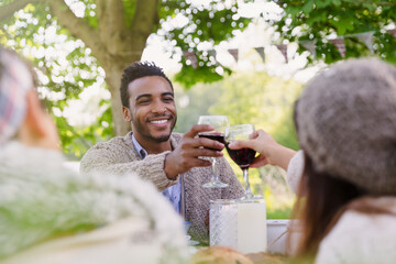 Couple toasting wine glasses at patio table