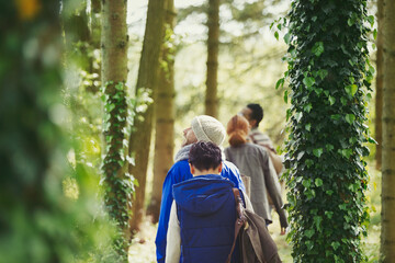 Friends hiking among ivy covered trees in woods