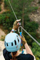 Young woman setting up a zipline or tyrolean.