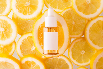 Vitamin C formula ampoule. Serum in transparent bottle with lemon flat lay on skice of lemons...