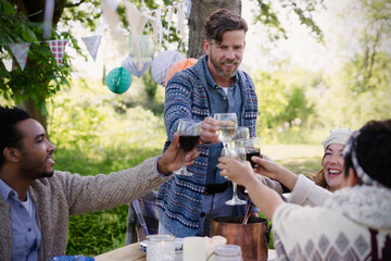 Friends toasting wine glasses at garden party table