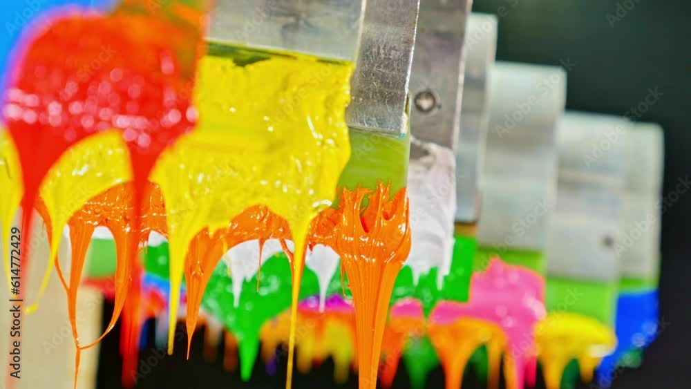 Poster colorful plastisol ink sticks are stretched on the printer handle..printing on tee shirts and fabric