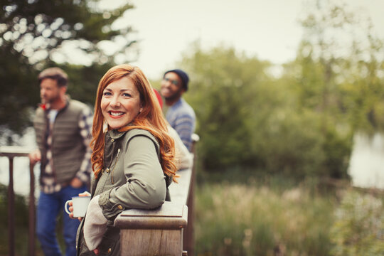 Portrait smiling woman drinking coffee with friends on balcony