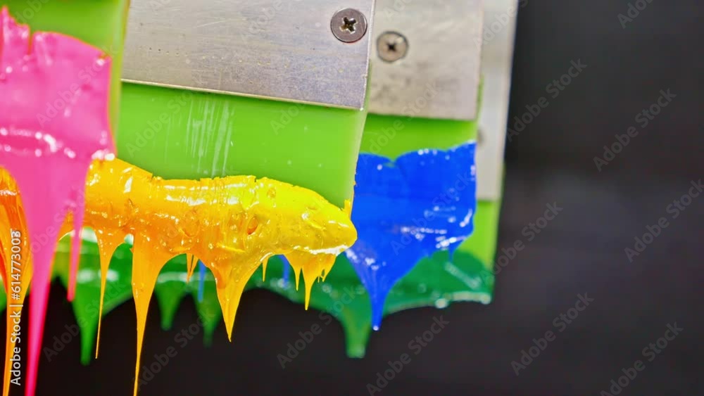 Poster colorful plastisol ink sticks are stretched on the printer handle..printing on tee shirts and fabric