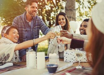 Friends toasting champagne glasses at birthday party patio table