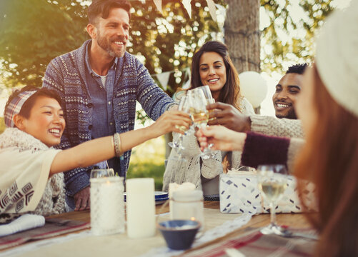 Friends toasting champagne glasses at birthday party patio table - Powered by Adobe