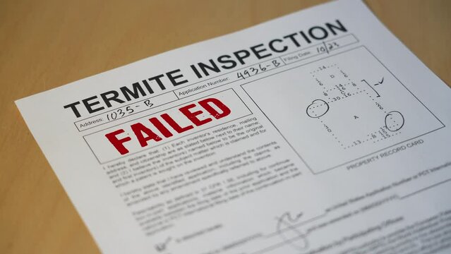 A closeup view of a termite home inspection is stamped FAILED. Data on form is fictional.  	