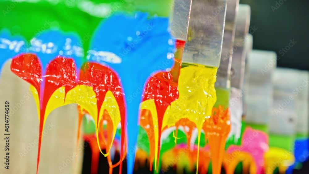 Poster colorful plastisol ink sticks are stretched on the printer handle..printing on tee shirts and fabric