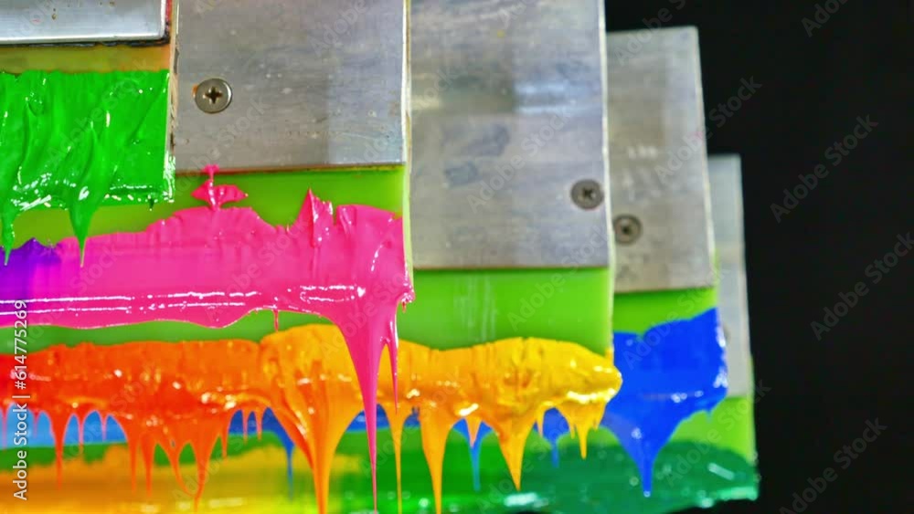 Poster colorful plastisol ink sticks are stretched on the printer handle..printing on tee shirts and fabric