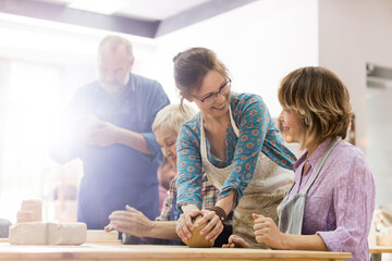 Mature women molding clay in pottery studio