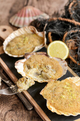 Coquilles saint-jacques farcies sur table en bois rustique avec un vieux filet de pêche