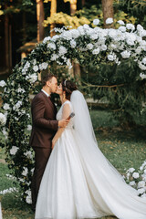 Beautiful wedding couple on the wedding autumn ceremony. the round arch is decorated with white...