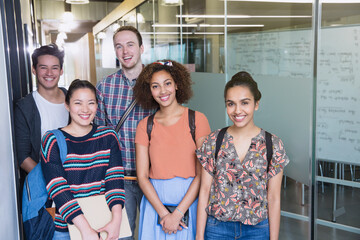 Portrait smiling college students in corridor