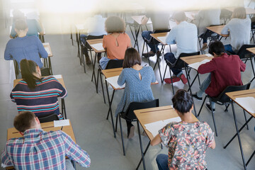 Fototapeta na wymiar College students taking test at desks in classroom