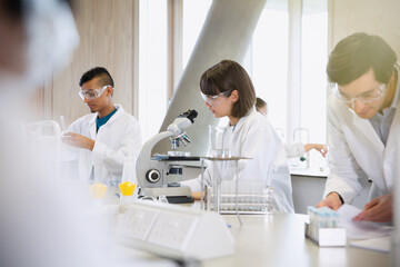 College students conducting scientific experiment in science laboratory classroom