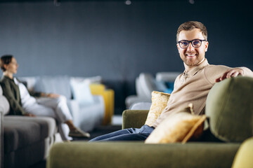Fototapeta premium Couple choosing sofa and pillows at furniture store