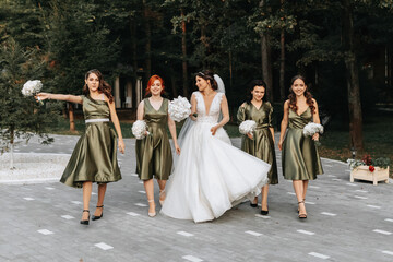 Beautiful bride and her friends- bridesmaids having fun after wedding ceremony. Happy girls at...