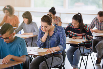 College students taking test at desks in classroom - obrazy, fototapety, plakaty