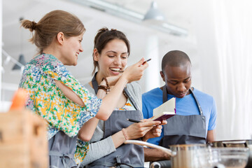 Women tasting food in cooking class kitchen