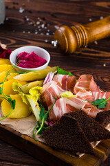 Fresh slices of bacon, boiled potatoes, pickles, garlic croutons, lettuce, horseradish and herbs.