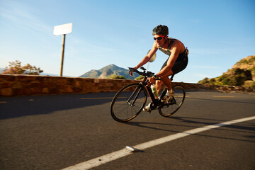 Male cyclist cycling on sunny corner