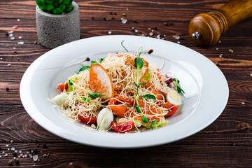Portion of Caesar salad with salmon, parmesan cheese, quail eggs, lettuce, tomatoes and croutons.