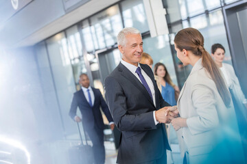 Business people greeting shaking hands in airport