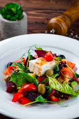 Lunch salad of fresh cucumber, tomato, sweet pepper, lettuce, feta cheese, olives, beets and Dijon mustard.