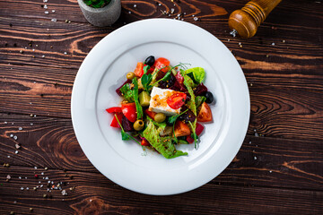 Dinner salad of fresh cucumber, tomato, sweet pepper, lettuce, feta cheese, olives, beets and Dijon mustard.