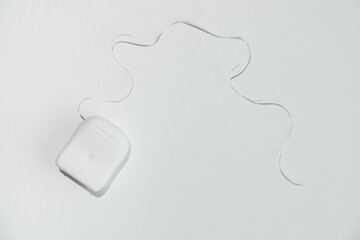 Container with dental floss on white background