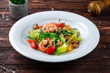 Fresh seafood salad of shrimp, mussels, cherry tomatoes oranges, grapefruits, capers, lettuce and arugula.