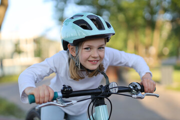 Close-up portrait, girls in a helmet on a bicycle.
