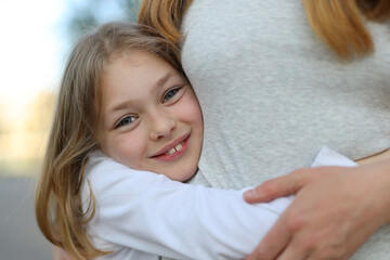 Portrait of a cute little baby girl hugging mom.
