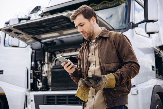 Truck driver stopped on the road reparing his lorry