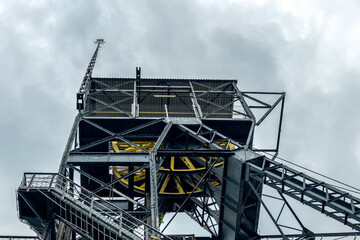 Shaft in the carnall zone. A steel structure adapted for an observation tower. Yellow hoist wheel....