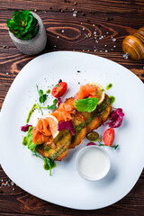Potato pancakes with salmon, capers, tomatoes, lettuce and sour cream, dinner.