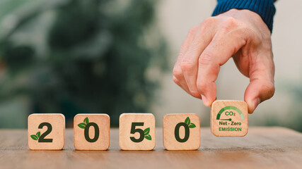 Zero by the year 2050. objective for reducing carbon. sustaining business practices. Limit your response to climate change. 2050 and a carbon reduction icon are displayed on wooden cubes. - obrazy, fototapety, plakaty